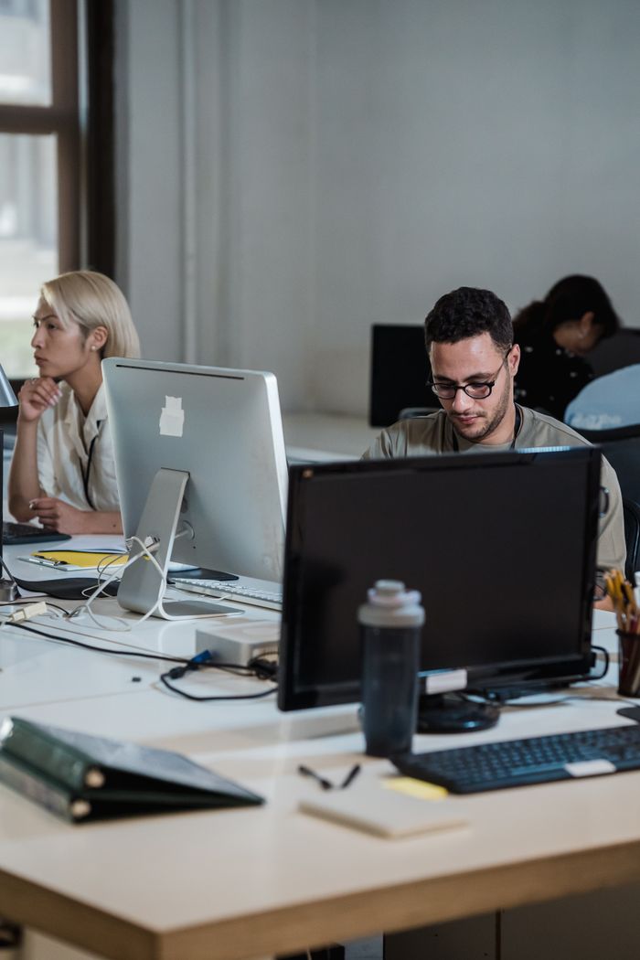 our-story Modern office space with diverse team working diligently at desks.